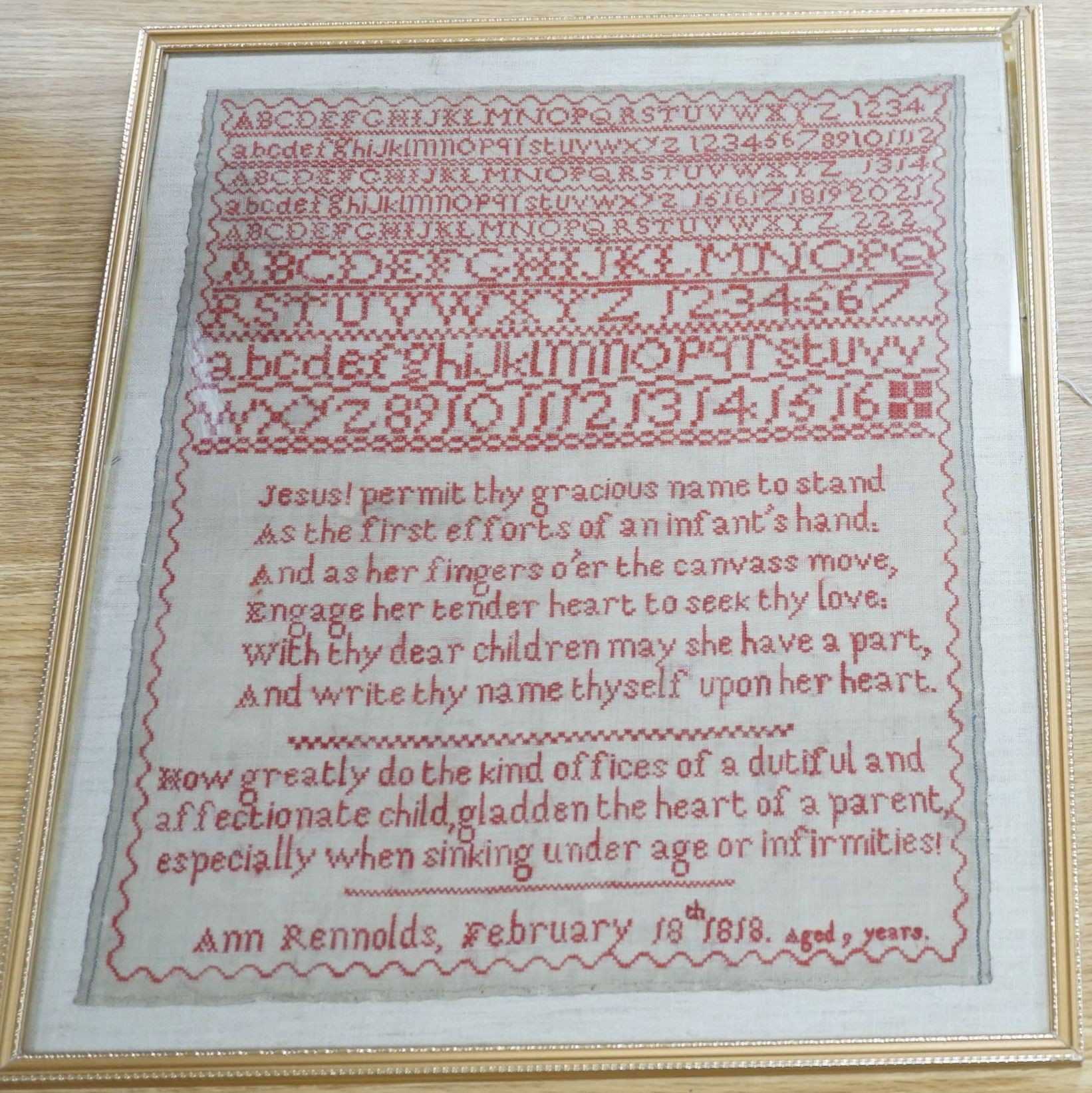 19th century red cross stitch sampler by Ann Reynolds, dated 1818, 34 cms wide x 42 cms high.